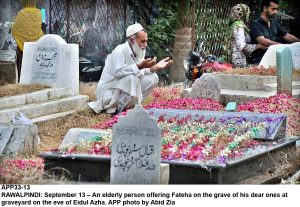 APP33-13 RAWALPINDI: September 13  An elderly person offering Fateha on the grave of his dear ones at graveyard on the eve of Eidul Azha. APP photo by Abid Zia