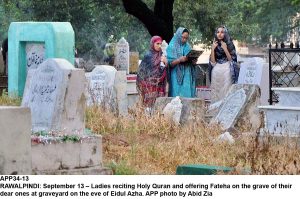 APP34-13 RAWALPINDI: September 13  Ladies reciting Holy Quran and offering Fateha on the grave of their dear ones at graveyard on the eve of Eidul Azha. APP photo by Abid Zia